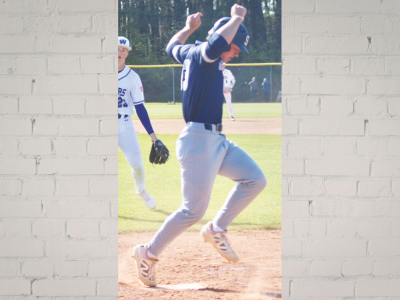 LAU – Mason Glover Baseball pitcher on the mound celebrating with arms raised as teammates watch in the background.