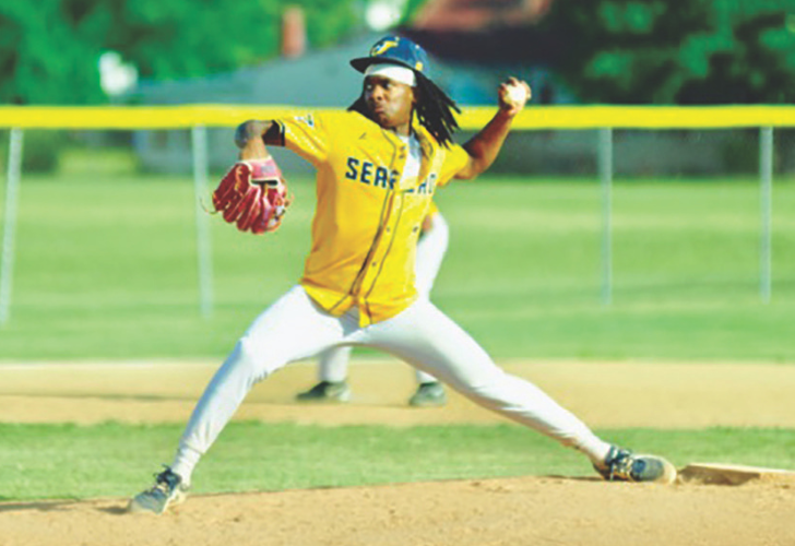 Baseball pitcher in a yellow uniform delivering a pitch on the mound during a game.