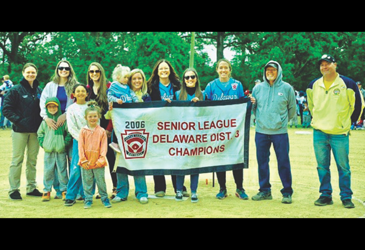 Group of players and supporters posing with a banner that reads 2006 Senior League Delaware Dist. 3 Champions on a grassy field.
