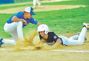 Kensell – Sports Baseball play: runner slides headfirst into a base as a fielder reaches to tag him, dirt flying around on a dirt infield.