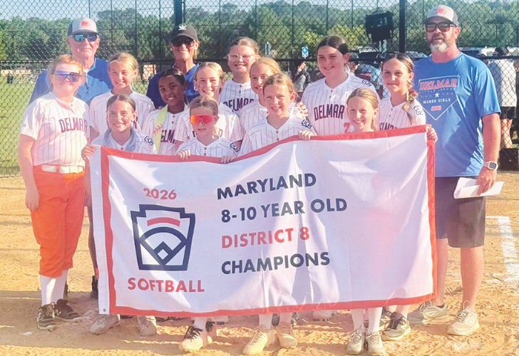 Minor League- Laurel 30- 7_9 pix Young girls in striped uniforms posing with coaches on a softball field, holding a banner that reads '2026 Maryland 8-10 year old District 8 Champions'.